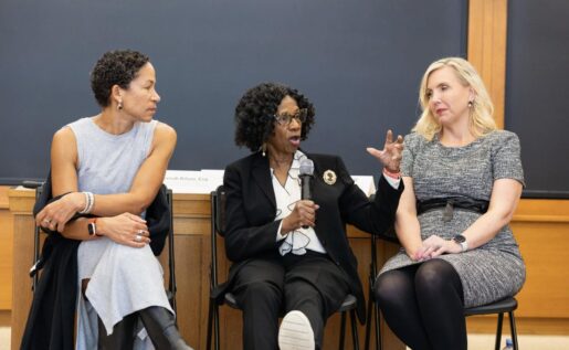 Three women speak in front of a Harvard law school classroom.